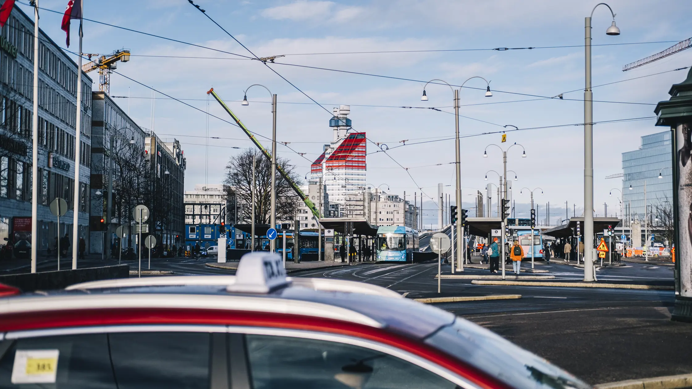 Bussar väntar vid Nordstans hållplats. I förgrunden syns en taxibil och i bakgrunden byggnaden Läppstiftet